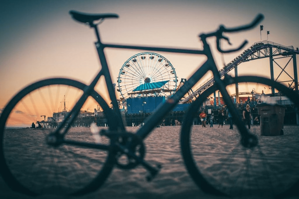 bicycle parked by sand with santa monica pier in the back, Hilton's Oceana Santa Monica, LXR Hotels & Resorts Guide